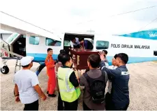  ?? — Bernama photo ?? The coffin carrying the body of Nur Adika being taken into the Cessna Caravan CE208 aircraft in Sandakan.