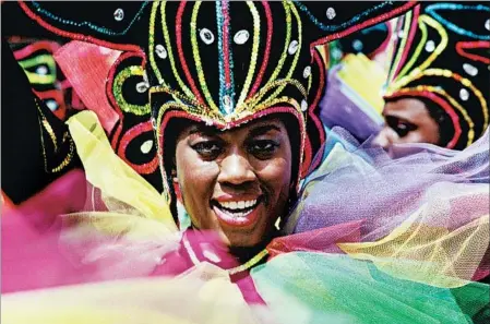  ?? DEAGOSTINI/GETTY ?? Some 60 costumed marching groups stream down the streets of Curacao’s capital of Willemstad during Carnival, to be held this year from Feb. 26-28.
