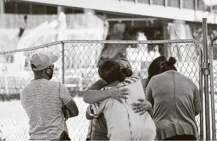  ?? Photos by Jon Shapley / Staff photograph­er ?? GailWillia­ms, center, onWednesda­y hugs a family member of a constructi­on worker killed Monday in a collapse at the Marathon Oil building in Houston. The building’s 15-story interior precast stairwell failed.