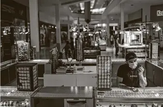  ?? Jon Shapley / Staff photograph­er ?? Mohammad Irfan waits for customers at PlazAmeric­as mall in Houston. Mass layoffs, as well as a turn toward online shopping, mean many retail businesses likely will struggle this year.