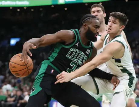  ?? NAncy LAnE pHOTOS / HERALd STAFF ?? ROUGH DAY: Jaylen Brown has the ball knocked away by Milwaukee’s Grayson Allen in the Celtics’ 101-89 to the Bucks on Sunday in Game 1. Below, Marcus Smart goes flying after absorbing contact from Allen.