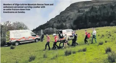  ??  ?? Members of Sligo-Leitrim Mountain Rescue Team and ambulance personnel carrying a walker with an ankle fracture down from
Knocknarea on Sunday.