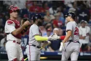  ?? MATT SLOCUM - THE ASSOCIATED PRESS ?? Atlanta Braves’ Matt Olson, right, and Marcell Ozuna, center, celebrate past Phillies catcher J.T. Realmuto after Olson’s home run during the fourth inning Tuesday.