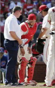  ?? CHARLES REX ARBOGAST — THE ASSOCIATED PRESS ?? St. Louis Cardinals trainer Chris Conroy, left, and manager Mike Matheny, right, attend to catcher Yadier Molina after Molina was injured on a pitch during the ninth inning of a baseball game against the Chicago Cubs Saturday in St. Louis.