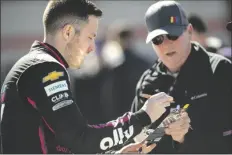  ?? HAKIM WRIGHT SR./AP ?? DRIVER ALEX BOWMAN (left) signs autograph before qualifying for the NASCAR Cup Series auto race at Atlanta Motor Speedway on Saturday in Hampton, Ga.