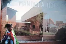  ?? MARKUS SCHREIBER AP FILE PHOTO ?? A girl sits outside the Mandela House Museum in the Soweto township in Johannesbu­rg as the funeral service for Nelson Mandela takes place in his ancestral village of Qunu, on Dec. 15, 2013.