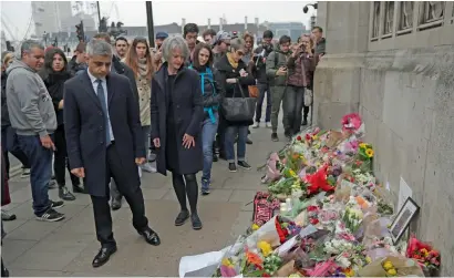  ?? AP ?? London Mayor Sadiq Khan looks at floral tributes to victims of Wednesday’s attack outside the Houses of Parliament in London, on Friday. —