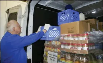  ?? MACOMB DAILY FILE PHOTO ?? A volunteer loads milk into a van at the Macomb Food Program warehouse. The nonprofit recently donated $50,000to help support the efforts of Macomb Community Action’s food bank to feed the needy across the county.