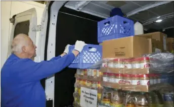  ?? MACOMB DAILY FILE PHOTO ?? A volunteer loads milk into a van at the Macomb Food Program warehouse. The nonprofit recently donated $50,000to help support the efforts of Macomb Community Action’s food bank to feed the needy across the county.