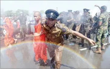  ?? ISHARA S KODIKARA/AFP ?? A Sri Lankan police personnel leads a monk from a protest in the southern port city of Hambantota on Saturday.