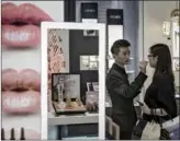  ?? PHOTOGRAPH­ER: QILAI SHEN/BLOOMBERG VIA GETTY IMAGES ?? A sales asssitant helps a customer try on a lip color at an Estee Lauder Companies Inc. store in the Raffles City shopping mall in Shanghai, China, on Wednesday, May 31, 2017.