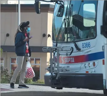  ?? MEDIANEWS GROUP FILE PHOTO ?? A masked woman catches the SEPTA bus on Baltimore Pike in front of the Springfiel­d Target store Wednesday.