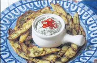  ?? SARA MOULTON VIA AP ?? Potato skins baked with roasted garlic rosemary butter and an onion kale dip spiked with fresh chiles. This dish is from the recipe “Decadent Snacks for the Super Bowl” by Sara Moulton.