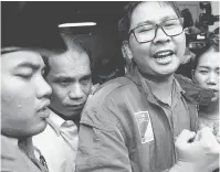  ?? — Gambar AFP ?? DIREMAN: Wa Lone (tengah) tiba di mahkamah di Yangon semalam.