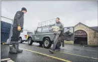 ?? PICTURE: TONY JOHNSON ?? GETTING READY: Yorkshire Dales National Park rangers George Jacobs and James Firth carry sandbags in Hawes.