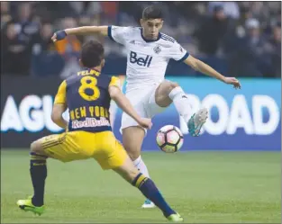  ?? The Canadian Press ?? Vancouver Whitecaps’ Matias Laba, right, gains control of the ball as New York Red Bulls’ Felipe defends during first-half CONCACAF Champions League quarter-final action in Vancouver on Thursday night.
