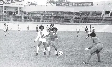  ?? FILE ?? Mark Cobran (centre) of Liguanea United shields the ball from Paul Williams of Elletson Flats in their Major League football match at the National Stadium in October 1975. At right is Liguanea’s goalkeeper Robert Noble. Liguanea United won the game 3-0.