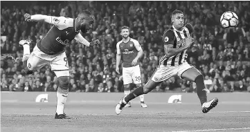  ??  ?? Arsenal’s French striker Alexandre Lacazette (left) scores his team’s first goal during the English Premier League football match against West Bromwich Albion at the Emirates Stadium in London. — AFP photo