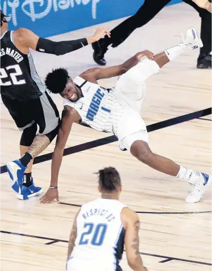  ?? CHARLES KING/ORLANDO SENTINEL ?? Magic forward Jonathan Isaac falls to the ground and injures his left knee in the fourth quarter Sunday against the Kings.