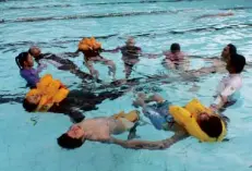  ??  ?? STUDENTS learn survival swimming from a Red Cross instructor.