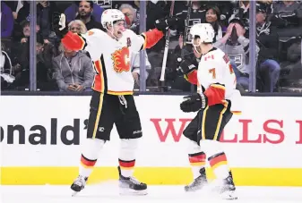  ?? Harry How / Getty Images ?? Sean Monahan celebrates with T.J. Brodie (7) after scoring in overtime as Calgary beat Los Angeles to improve to 3-1 — its best start since it was 4-0 to open the 2009-10 season.