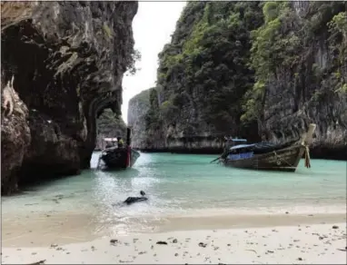  ?? COURTNEY BONNELL — THE ASSOCIATED PRESS ?? In this photo, long-tail boats sit near a small beach on Ko Phi Phi Leh, an island off the southweste­rn coast of Thailand. The smaller of the Phi Phi Islands is a tourist hotspot for its beautiful water, party atmosphere and famed Maya Bay, where the...