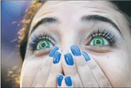  ?? — Photo by The Associated Press ?? A Brazilian soccer fan wearing contact lenses that mimic Brazil’s flag watches her team lose 7-1 to Germany in their World Cup semifinal game via live telecast inside the FIFA Fan Fest area on Copacabana beach in Rio de Janeiro on Tuesday.