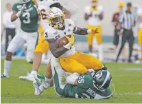  ?? AL GOLDIS/ASSOCIATED PRESS ?? Arizona State’s Eno Benjamin is tackled by Michigan State’s Joe Bachie on Saturday in East Lansing, Mich. Arizona State beat the No. 18 Spartans 10-7, and Sunday, the Sun Devils were ranked No. 24.
