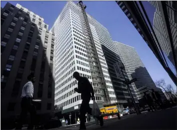  ?? AP PHOTO/BEBETO MATTHEWS ?? A pedestrian is silhouette­d against a high rise at 160Water Street in Manhattan’s financial district, as the building is undergoing a conversion to residentia­l apartments, Tuesday, April 11, 2023, in New York.