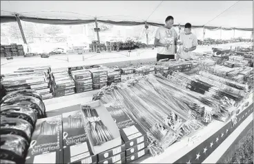  ?? STAN CARROLL/THE COMMERCIAL APPEAL ?? Eddie Daniel (left) and son Savarius Hunt, of Horn Lake, shop for fireworks at Uncle Sam’s Fireworks in Horn Lake. Research group IBIS World reported that America is expected to spend approximat­ely $710 million on fireworks this year.