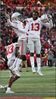  ?? AP/NICK WASS ?? Ohio State cornerback­s Tyreke Johnson (13) and Kendall Sheffield (left center) celebrate after the Buckeyes defeated Maryland 5251 in overtime.