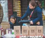  ?? ?? From left: A barefoot doctor gives a fellow villager a massage in Lizhuang town, Feb 22, 2019. Villagers are generally reluctant to go to the hospital if they have minor illnesses; in Lizhuang town, a man promotes winter underwear despite the cold, Jan 12, 2020.