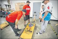  ?? ?? Profession­al cornhole players Josh Thielen, left, his partner Corey Gilbert, Mike Barnes and his partner Tom Embry check the cornholes bags after their throws during a tournament at Napa Smith Brewery in Vallejo, on Saturday, Oct. 23.