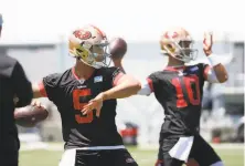  ?? Jim Gensheimer / Special to The Chronicle ?? Niners quarterbac­ks Trey Lance (5) and Jimmy Garoppolo warm up at organized team activities on June 2 in Santa Clara.