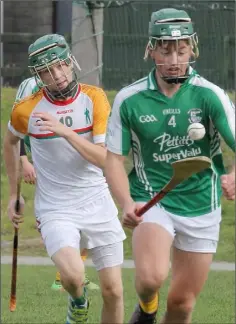  ??  ?? Brian Cushe of Naomh Eanna soloing out of defence as Na Piarsaigh’s Mylie Connors looks on.