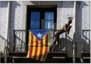  ?? MANU FERNANDEZ / AP ?? On a balcony Monday in Barcelona, Spain, a mannequin stands next to an “estelada,” the independen­ce flag of Catalonia. The region’s president says he has a mandate to declare a Catalan republic.