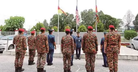  ??  ?? Fire and Rescue Department officer Mohd Azril Abdul Kadir with other firefighte­rs in Shah Alam yesterday. Flags were flown half-mast in honour of the six firemen who died.