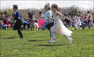  ?? BILL LACKEY/STAFF ?? Hundreds of children and their parents scramble across the driving range at Young’s Jersey Dairy as they participat­e in the 37th annual Easter Egg Hunt at Young’s Dairy Sunday. The event that started with a few dozen eggs and a couple children has turned into a monumental event where they color 10,000 hard boiled eggs each year for hundreds of children.