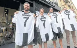  ??  ?? Juventus supporters in Turin buy Ronaldo’s jerseys after his move to the Italian club.