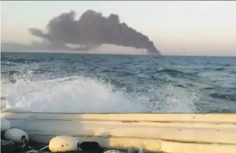  ?? / Asriran.com ?? Smoke rises from Iran’s navy warship Kharg, which caught fire and sank in the Gulf of Oman under unclear circumstan­ces. Some 400 sailors and cadets were forced to flee the vessel.