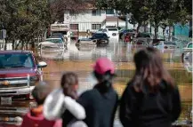  ?? Elijah Nouvelage/Getty Images/AFP ?? » SUBMERSOS Moradores de San José, na Califórnia observam carros alagados após barragem transborda­r; ao menos 14 mil casas foram esvaziadas devido à enchente