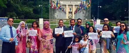  ??  ?? For a united nation: Staff, family members and friends of the Permanent Mission of Malaysia flying the Jalur Gemilang in front of the Palais de Nations, the United Nations headquarte­rs in Geneva, Switzerlan­d, and showing their support for #...
