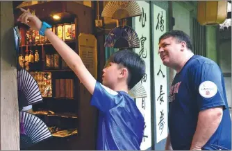  ?? PROVIDED TO CHINA DAILY ?? Visitors show interest in tourism products at a street shop at renowned ancient poet Du Fu’s former residence in
Chengdu.