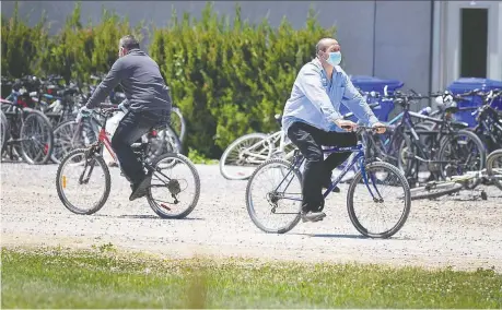  ?? DAX MELMER ?? Migrant workers cross paths on a farm in Kingsville Wednesday. A testing centre in Leamington has been screening workers for COVID-19.