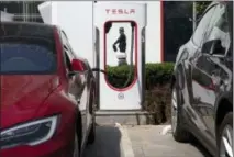  ?? NG HAN GUAN — THE ASSOCIATED PRESS FILE ?? A security guard moves past an electric vehicle charging station in Beijing.