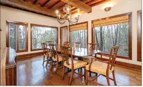  ?? ?? The formal dining room provides a wood beamed ceiling, a candle chandelier and eight windows.