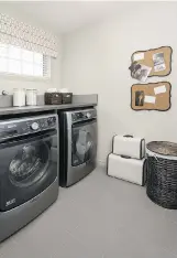  ??  ?? The spacious laundry room in the Envoy features frontload washer and dryer.