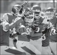  ?? NWA Media/BEN GOFF ?? Arkansas defensive end Trey Flowers (center) is mobbed by teammates after his intercepti­on in the first quarter. It was Flowers’ first career intercepti­on.