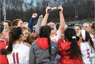  ?? Photo by Jerry Silberman / risportsph­oto.com ?? Mount senior Katie Lynch celebrates with the Division II plaque after the Mounties defeated Pilgrim in a penalty shootout. Coach Phil Pincince believed in Monday’s result when he was hired.
