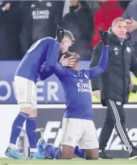  ?? Picture: Reuters ?? WINNING GOAL. Leicester City’s Kelechi Iheanacho celebrates scoring their second goal with James Maddison and manager Brendan Rodgers during their match against Everton yesterday.